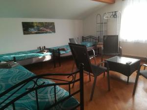 a room with three beds and a table and chairs at 3072 Apartment MITTERFELD - Top B in Kasten bei Böheimkirchen