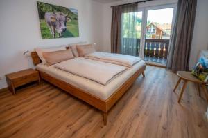 Un dormitorio con una cama y una ventana grande. en Ferienwohnung Bergnasennen, en Pfronten