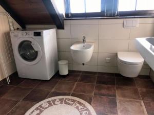 a bathroom with a washing machine and a sink at Ferienwohnung Turmzimmer für 4 Personen in Leppersdorf