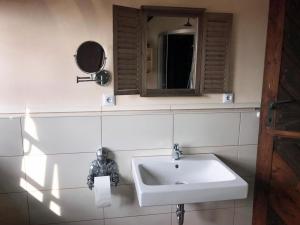 a bathroom with a sink and a mirror at Ferienwohnung Turmzimmer für 4 Personen in Leppersdorf