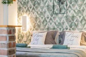 2 cuscini su un letto in una camera con parete di La Petite Maison a Bédoin Altre 24 foto