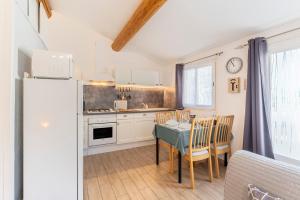 eine Küche mit einem Tisch und einem Kühlschrank in der Unterkunft La Petite Maison in Bédoin
