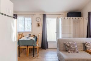 un soggiorno con un tavolo e un divano di La Petite Maison a Bédoin