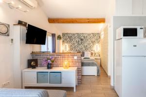 Camera piccola con 2 letti e un muro di mattoni di La Petite Maison a Bédoin