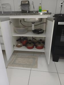 uma cozinha com um lavatório e algumas panelas debaixo de um balcão em Flat Smart Residence em Teresina