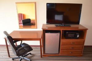 a desk with a television and a chair in a room at Royal Inn Greenville in Greenville