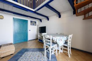 ein Esszimmer mit einem Tisch, Stühlen und einer blauen Tür in der Unterkunft [Sorrento Coast] - Double Suite On The Sea in Meta