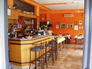 a restaurant with a bar with stools in a room at Hotel Du Lac in Moniga