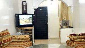 sala de estar con puerta negra y TV en 2 bedrooms apartement with garden at Kenitra, en Kenitra