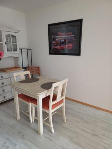 a dining room table with two chairs and a tv at Apartment Flughafen Leipzig in Hayna