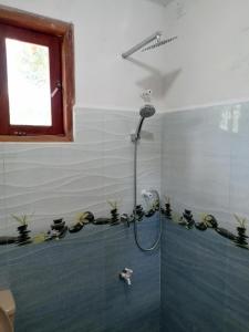 bagno con doccia e piante sul muro di Sinharaja Cabana a Matara