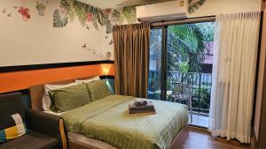 a bedroom with a bed and a window with a balcony at La Habana HuaHin by ABCD in Hua Hin +77 photos