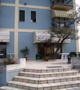 un edificio azul con escaleras delante de un edificio en Hotel Du Lac en Moniga