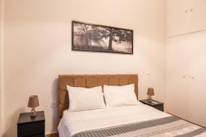a bedroom with a bed with white sheets and two lamps at Apartment @Katehaki Metro in Athens