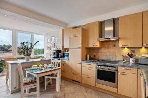 a kitchen with wooden cabinets and a small table with chairs at Odenwald Ferienwohnung in Schönbrunn