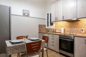 cocina con mesa, sillas y encimera en Apartment @Katehaki Metro en Atenas