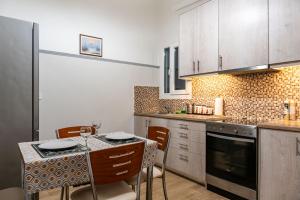 a kitchen with a table and chairs and a counter top at Apartment @Katehaki Metro in Athens