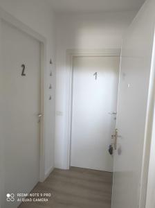 an empty room with two white doors and wood floors at Besmir's in Golem