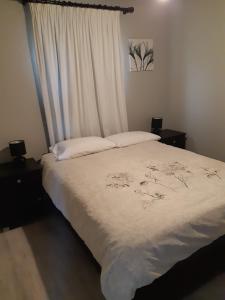 - une chambre avec un lit doté de draps blancs et une fenêtre dans l'établissement Oak Terrace 39, à Hermanus