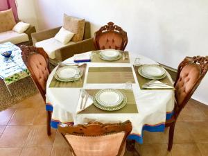 a dining room table with plates on it with a couch at Elegant villa in Dar Bouazza with year-round private pool in Dar Bouazza