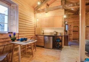 a kitchen with wooden walls and a table in a room at Dog Crag Cabin in Silecroft