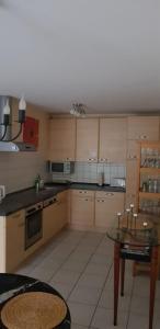 a kitchen with wooden cabinets and a table in it at Souterrain - a72405 in Rheinbach