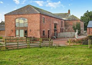 uma casa de tijolos com uma cerca em frente em Turret at Hadrians Wall em Irthington