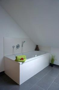 een witte badkamer met een bad in de kamer bij Ferienwohnung Ottobeuren in Ottobeuren