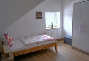 een slaapkamer met een bed en een raam erin bij Ferienwohnung Ottobeuren in Ottobeuren
