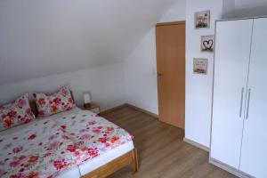 een slaapkamer met een bed en een witte kast bij Ferienwohnung Ottobeuren in Ottobeuren