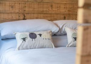 Una cama con dos almohadas con ovejas. en Esk Escape, en Longtown