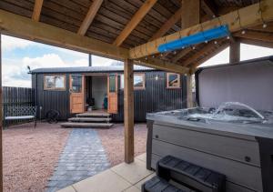 an outdoor kitchen with a pergola and a house at Esk Escape in Longtown