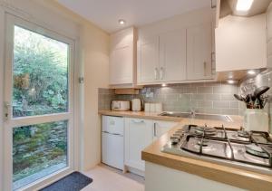 a kitchen with white cabinets and a large window at Lingmoor Lookout in Chapel Stile