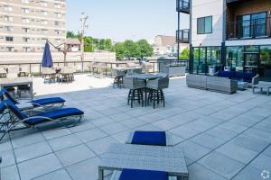 a patio with chairs and tables on a building at Brand New 2 Bedroom Apartment Steps from Mayo! in Rochester