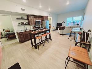 a living room with a kitchen with bar stools at Brand New 2 Bedroom Apartment Steps from Mayo! in Rochester