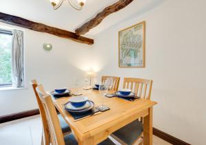 comedor con mesa de madera y sillas en Rosie Cottage, en Bassenthwaite