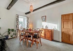 a dining room with a wooden table and chairs at Pear Tree Cottage - Solway Coast in Bowness-on-Solway