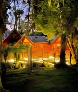 an orange house with lights in the yard at Cabana Suspensa na Natureza - Região Turística in Campos do Jordão