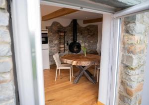 a dining room with a table and a stone wall at Beltie in the Vale in Threlkeld