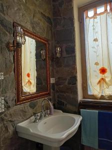 bagno con lavandino e specchio di La Casa Nel Bosco a Beverino