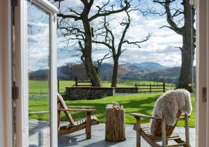 a porch with a view of a field with a sheep at Beltie in the Vale in Threlkeld