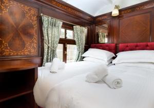 a bedroom with two beds with white sheets at Esk Pullman Carriage in Ravenglass
