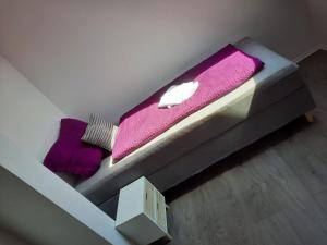 a bed with a purple blanket on top of it at Villa Mariensiel 2OG li in Sande