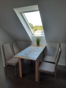 mesa y sillas en una habitación con ventana en Villa Mariensiel 2OG li, en Sande