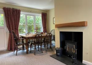 a dining room with a table and chairs and a fireplace at Station Masters Cottage - Ravenglass in Ravenglass