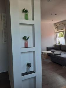 a living room with two potted plants on shelves at Villa Mariensiel 2OG li in Sande