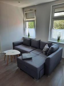 ein Wohnzimmer mit einem Sofa und einem Tisch in der Unterkunft Villa Mariensiel 2OG li in Sande