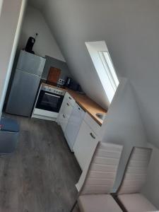 eine Küche mit weißen Schränken und eine Treppe mit einem Fenster in der Unterkunft Villa Mariensiel 2OG li in Sande