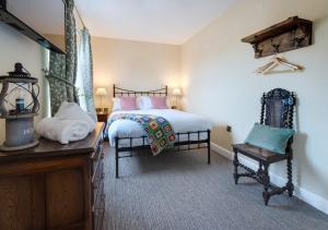 a bedroom with two beds and a table and a chair at Station Masters Cottage - Ravenglass in Ravenglass