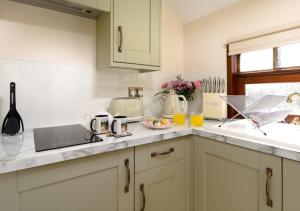 a kitchen with white cabinets and a counter top at Irt Pullman Carriage in Ravenglass